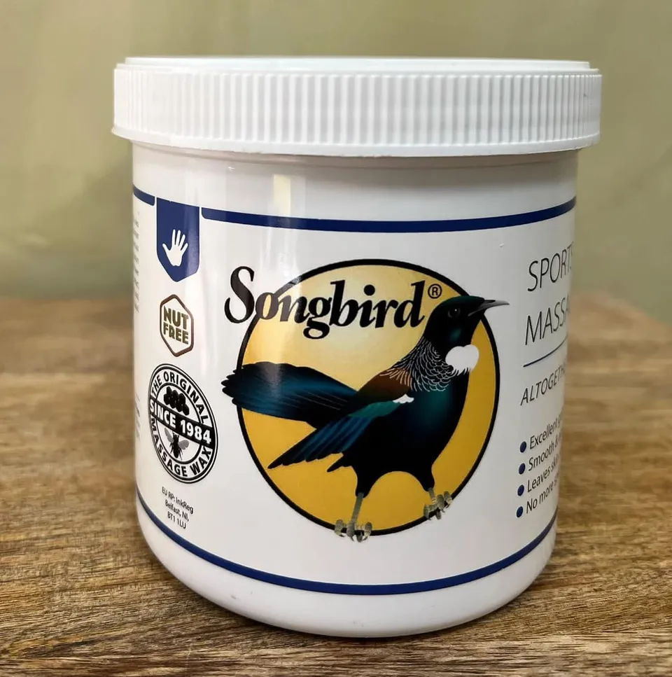 Pot Songbird sports massage wax op een houten tafel