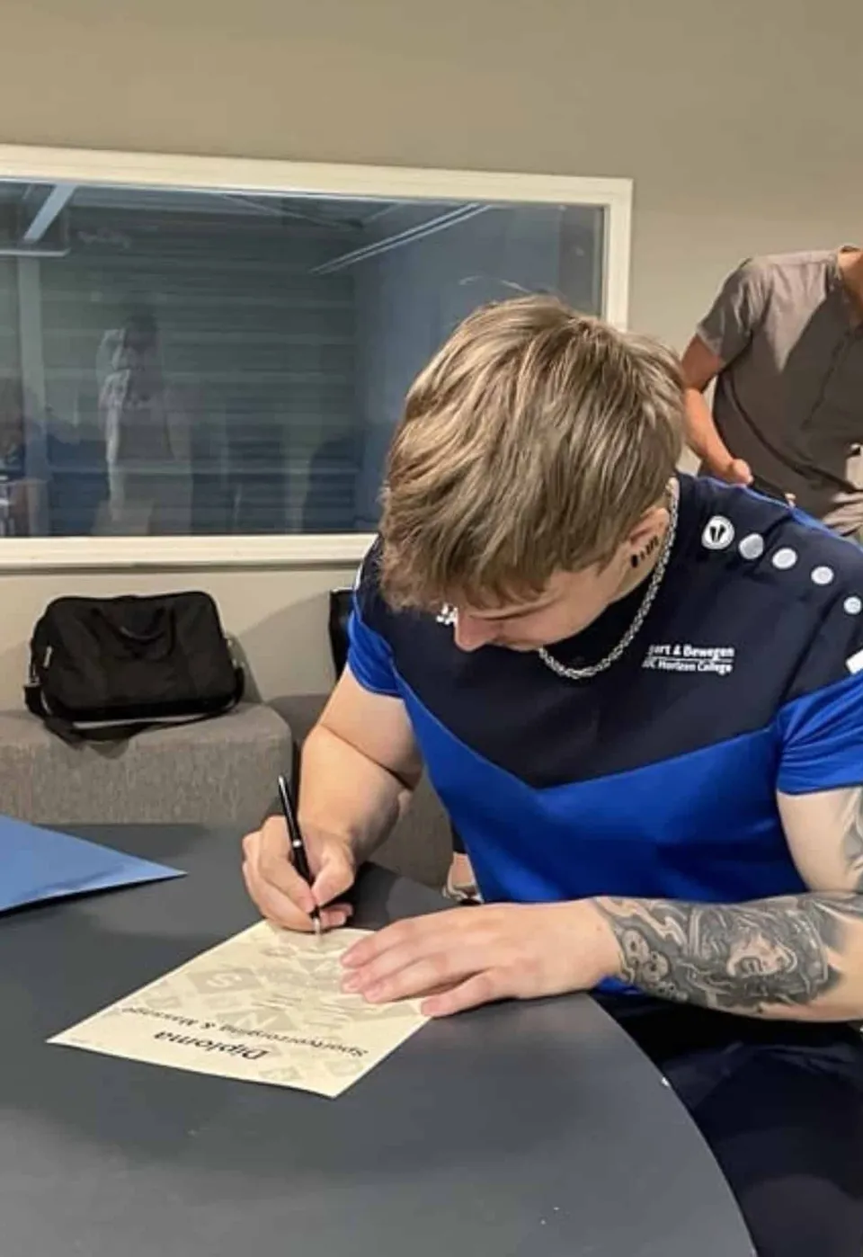 Jelmer ondertekent zijn diploma Sportverzorging & Massage